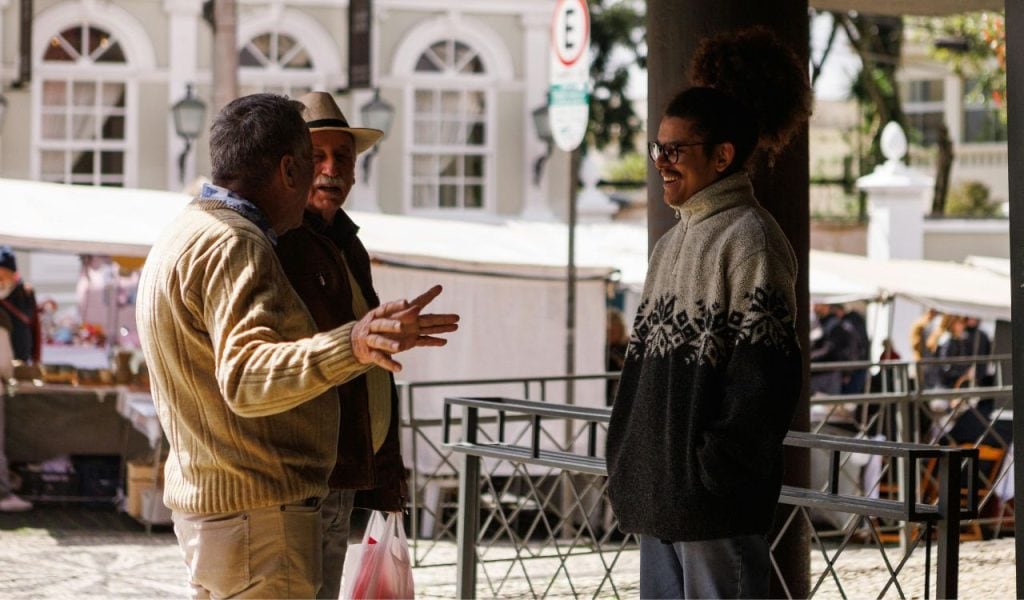 Three People Talking in a City