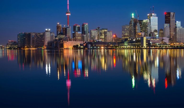 Buildings Near Body Of Water At Night