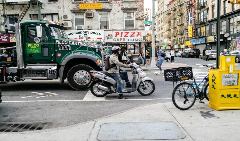 A Person Riding a Motorcycle Scooter on the Road 