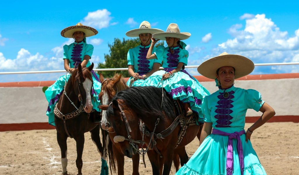 Women in Mexican Blue Dresses Posing with Horses
