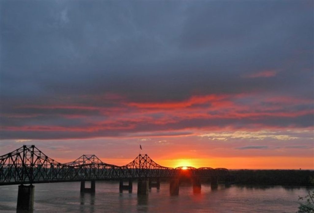 The sun sets dramatically over the Mississippi River along Mississippi's Great River Road.