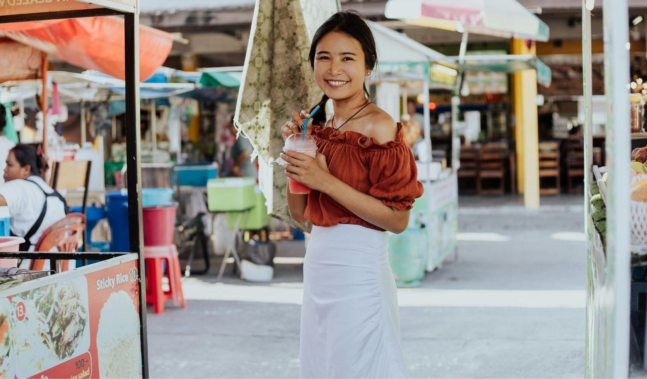 A Woman Smiling and Holding a Smoothie Drink