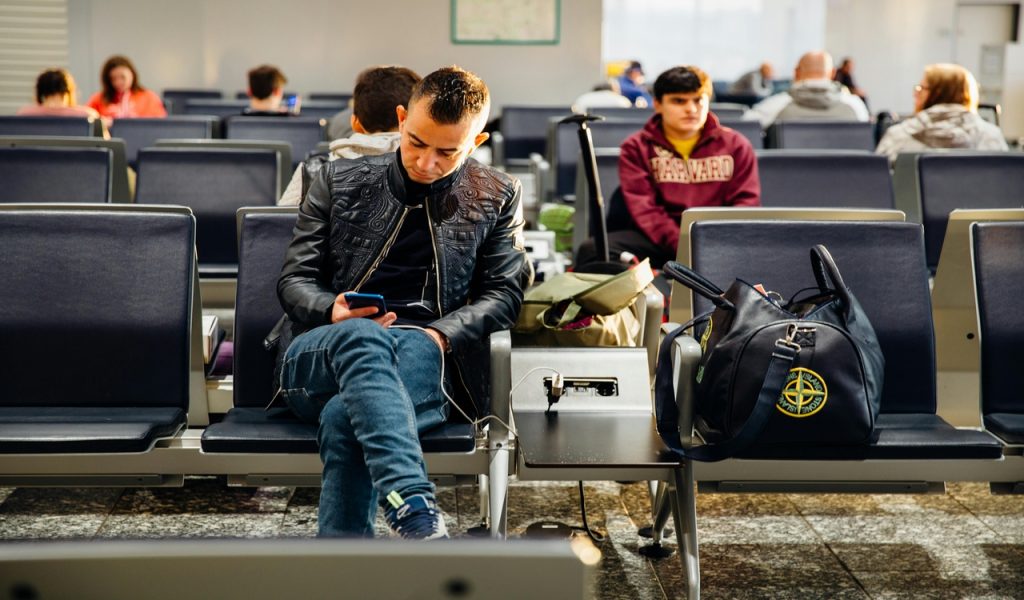 10 Airport Habits That Keep Devices Safe During October Travel – Her Life Adventures Man in Black Leather Jacket Sitting on Chair