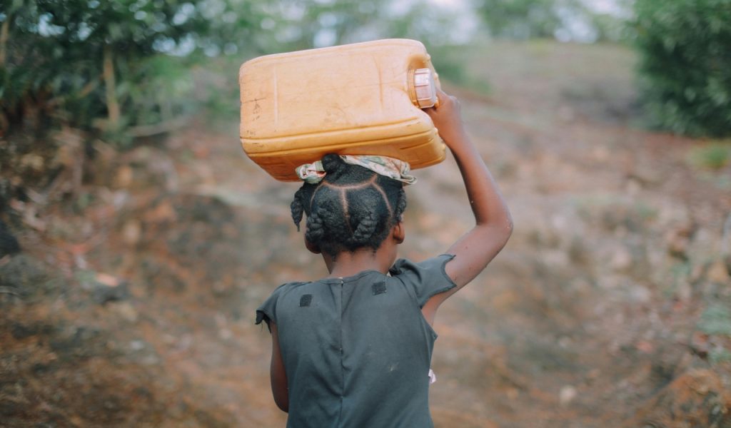 Photo of Child Carrying Jug