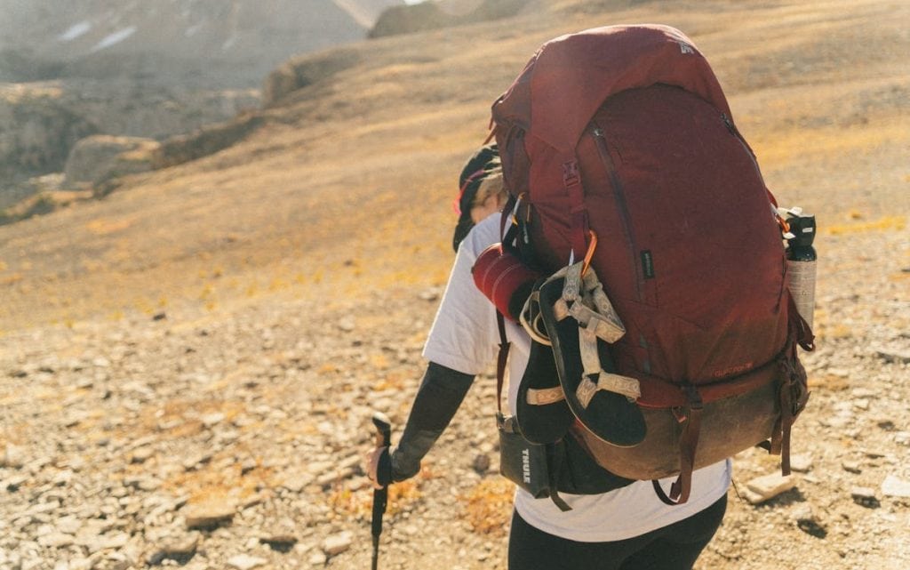 8 Travel Gear Items To Leave At Home For October Trips – Her Life Adventures A Man Carrying a Backpack in Mountains