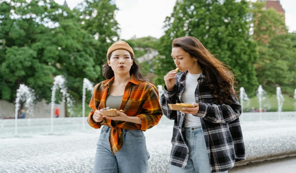 Femmes mangeant en marchant dans le parc