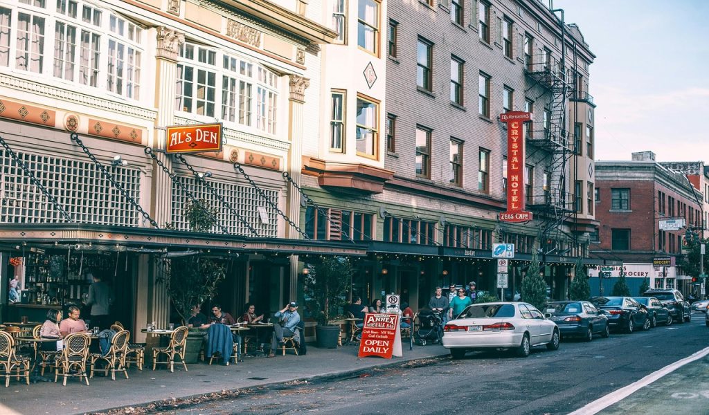 House with cafe and parked cars in city 