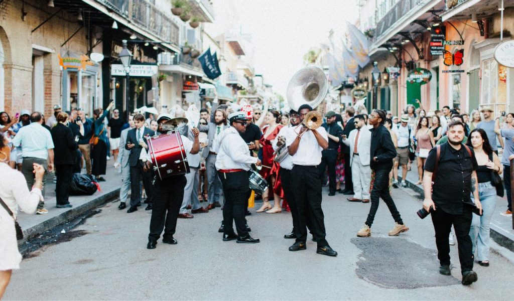 Les gens regardent des musiciens jouer lors d'une fête de rue à la Nouvelle-Orléans, aux États-Unis