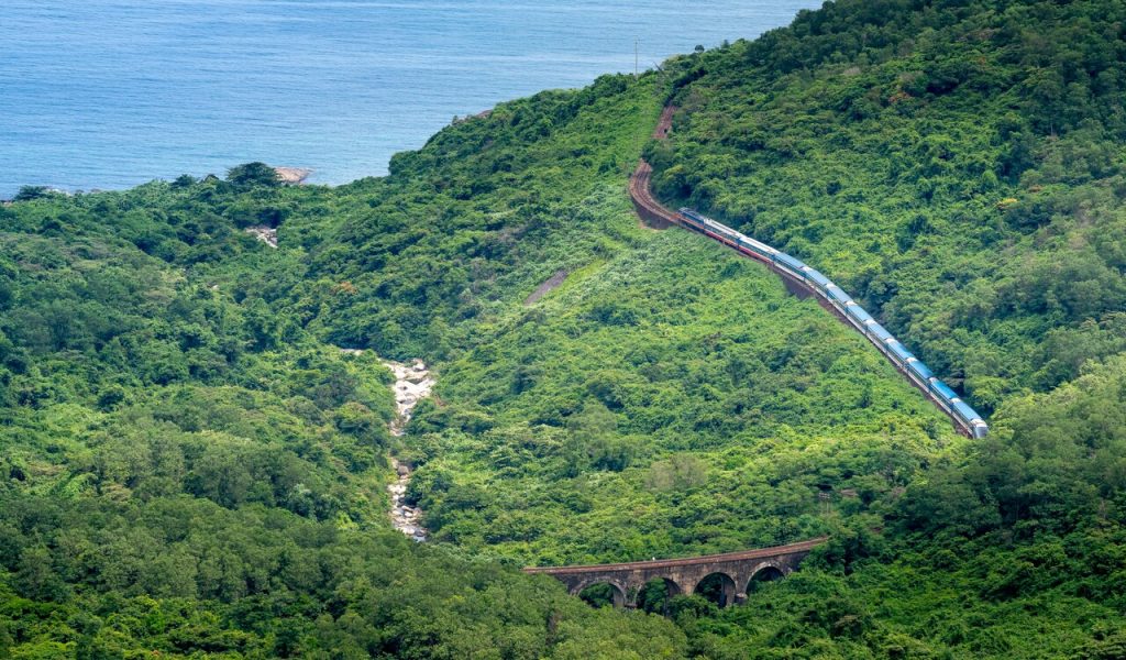 9 Countries With the Most Stunning Train Journeys – Her Life Adventures Train driving on railway in green mountains
