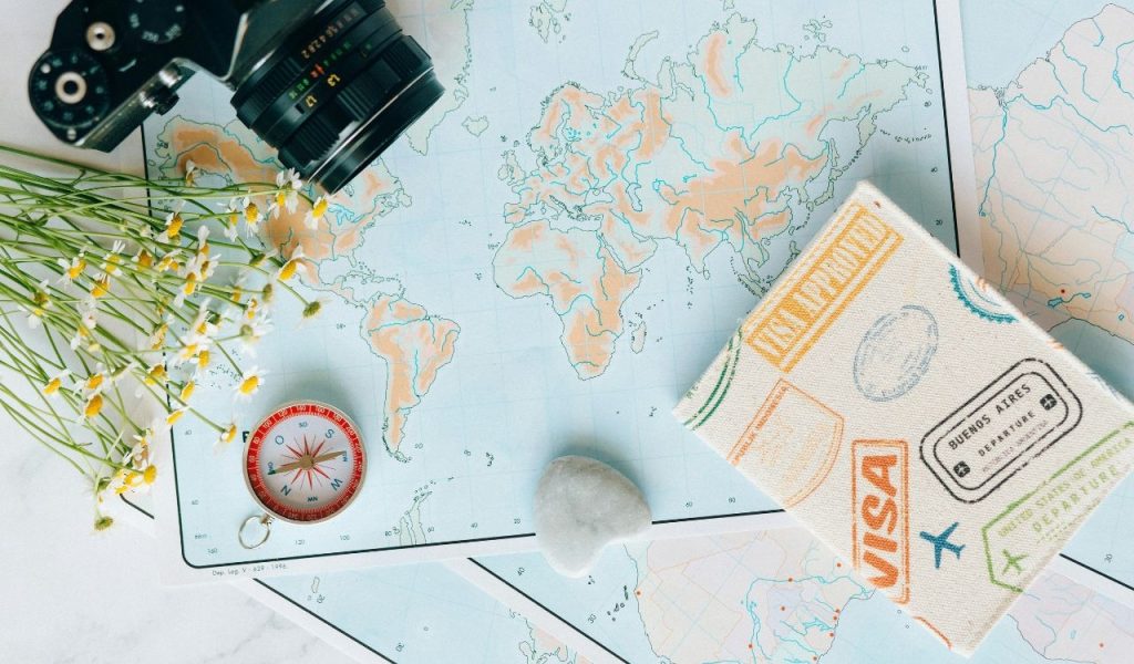 Overhead Shot of a Camera and Flowers Near a Map