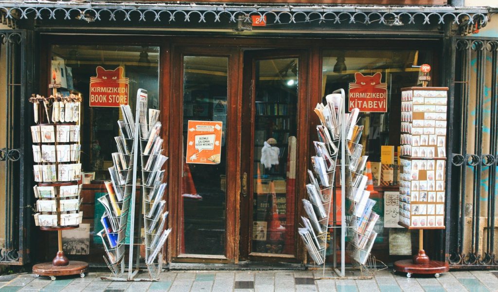 Charming bookstore entrance with outdoor magazine racks
