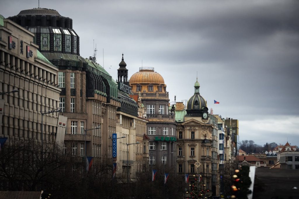 A row of buildings with a cloudy sky above them
