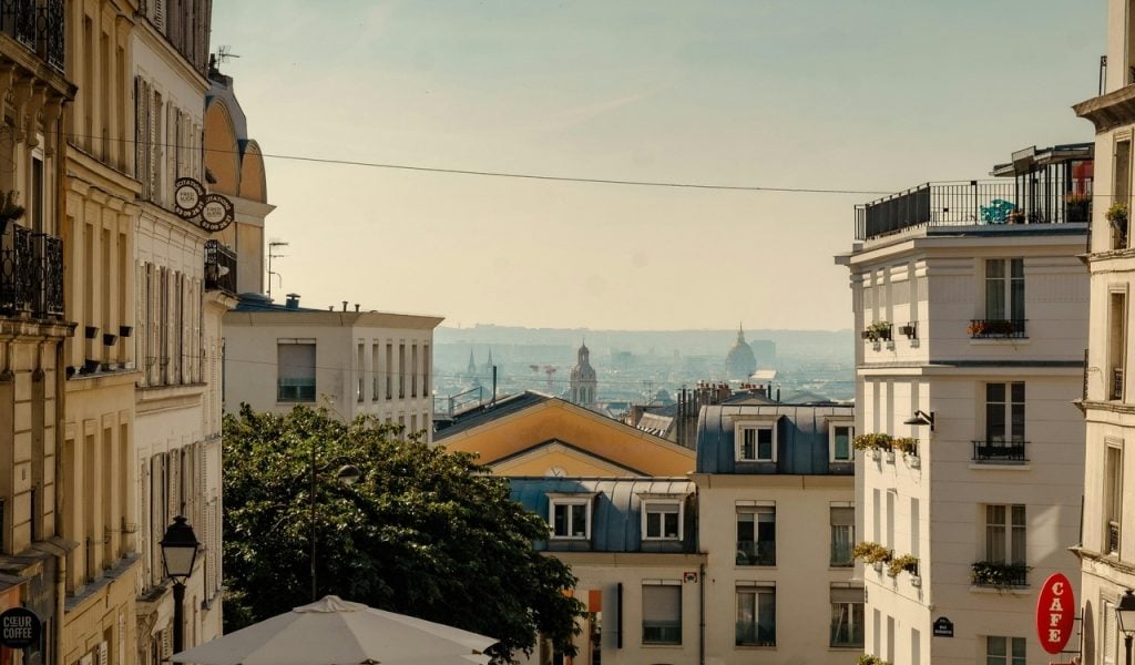 15 Bucket-List Destinations Frequent Travelers Love – Her Life Adventures Charming Parisian Street View with Distant Cityscape