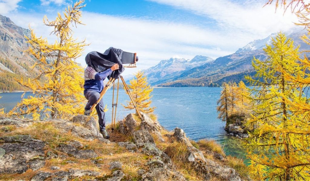 Landscape photographer with medium format vintage film plate camera
