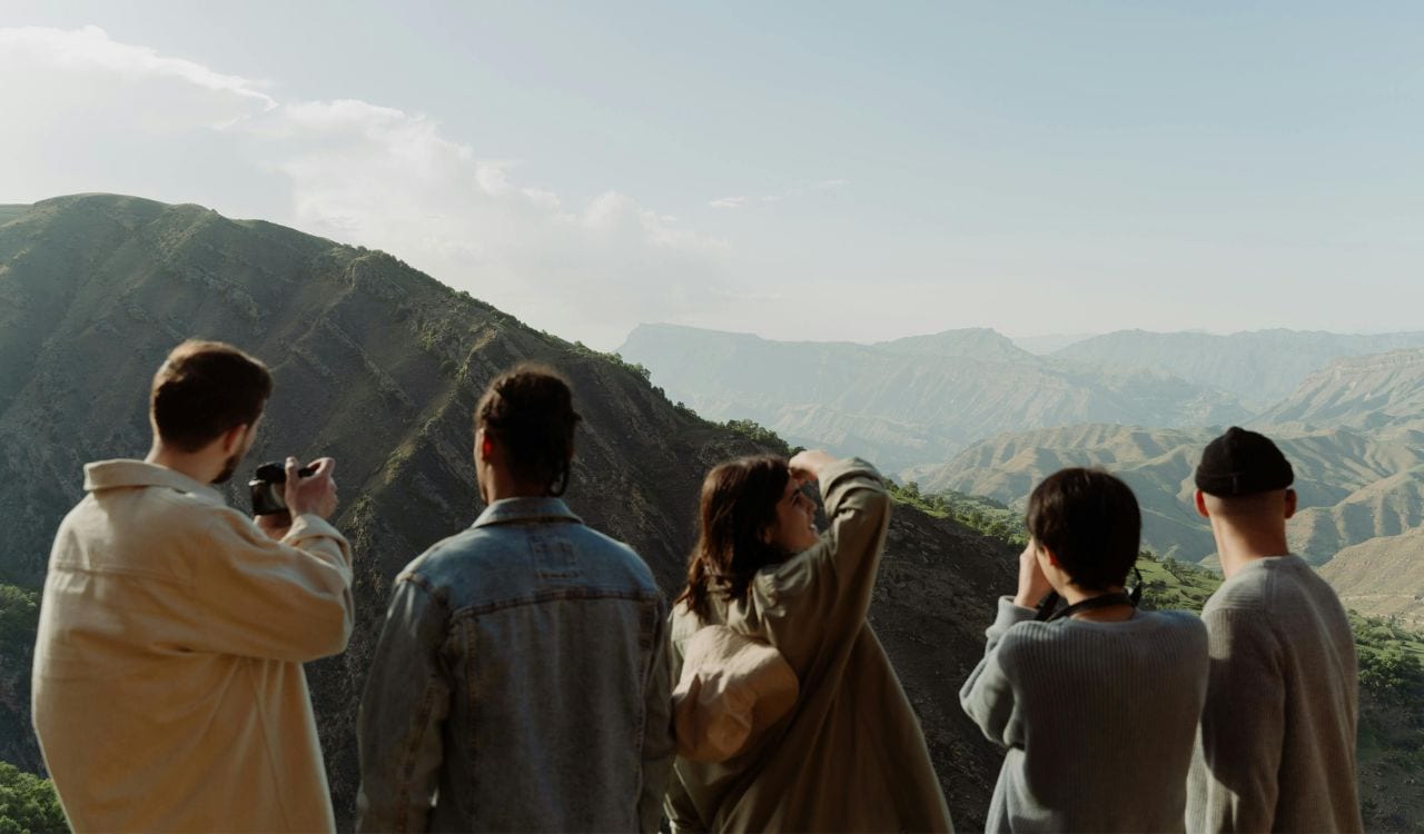 Group of People Taking Pictures of a Mountain