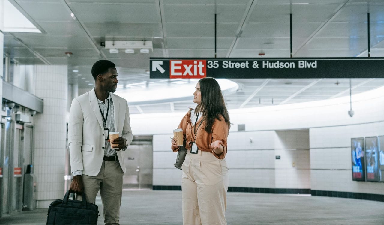 Man and Woman Wearing ID Badges on a Subway Station