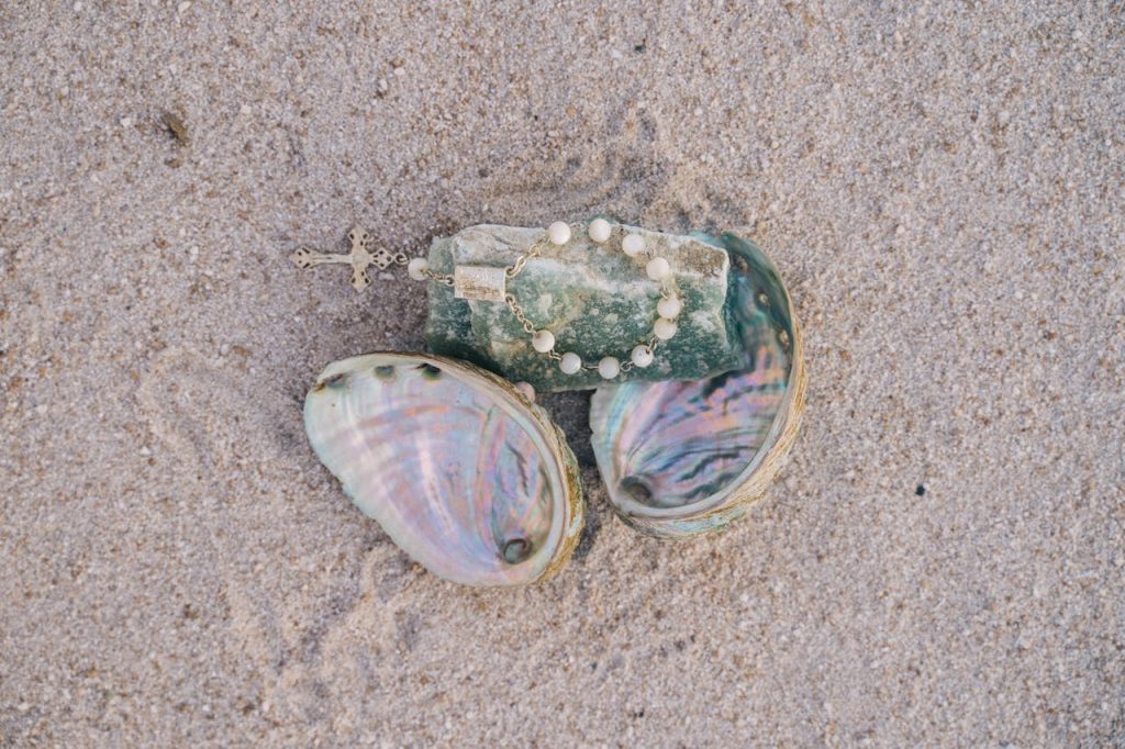 10 Things You Can’t Legally Collect On A Beach – Her Life Adventures A Rosary On Green Stone On Top of Seashells
