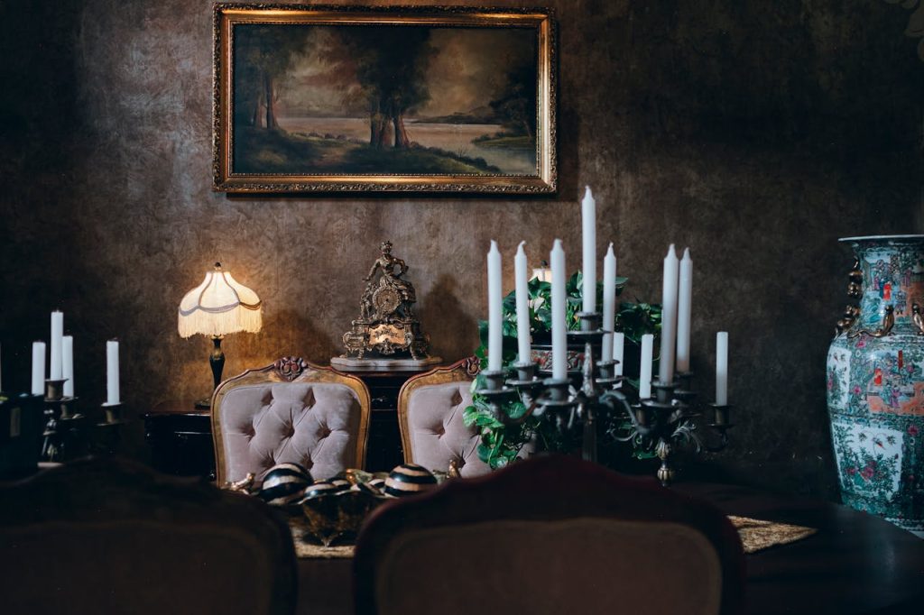 Dimly lit Victorian-style mansion interior with antique furniture and candlelight.