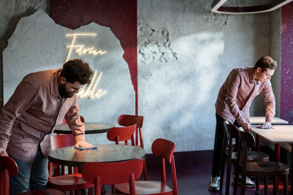 Two Waiters Cleaning Dining Table