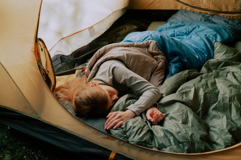 8 Travel Gear Items To Leave At Home For October Trips – Her Life Adventures A Woman Sleeping in a Tent