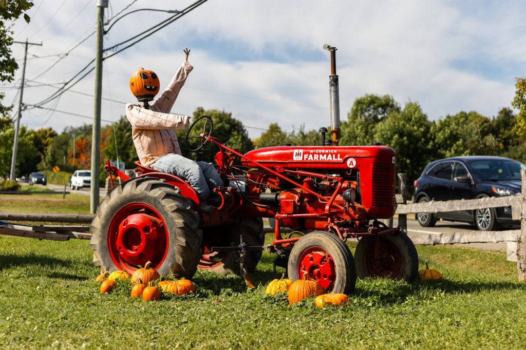 Pumpkin Head on Vintage Tractor in Fall Setting