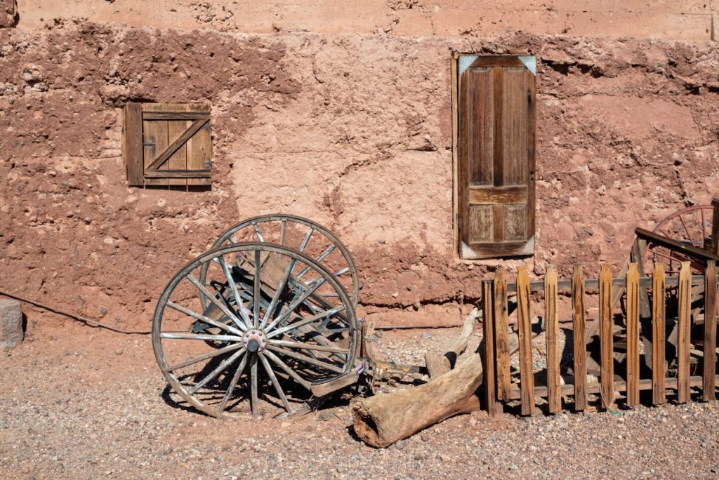 Abandonded Horse Cart with Spoked Wheels near a Rural House in Calico Ghost Town, USA

