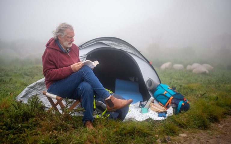A Man reading a Book beside His Tent