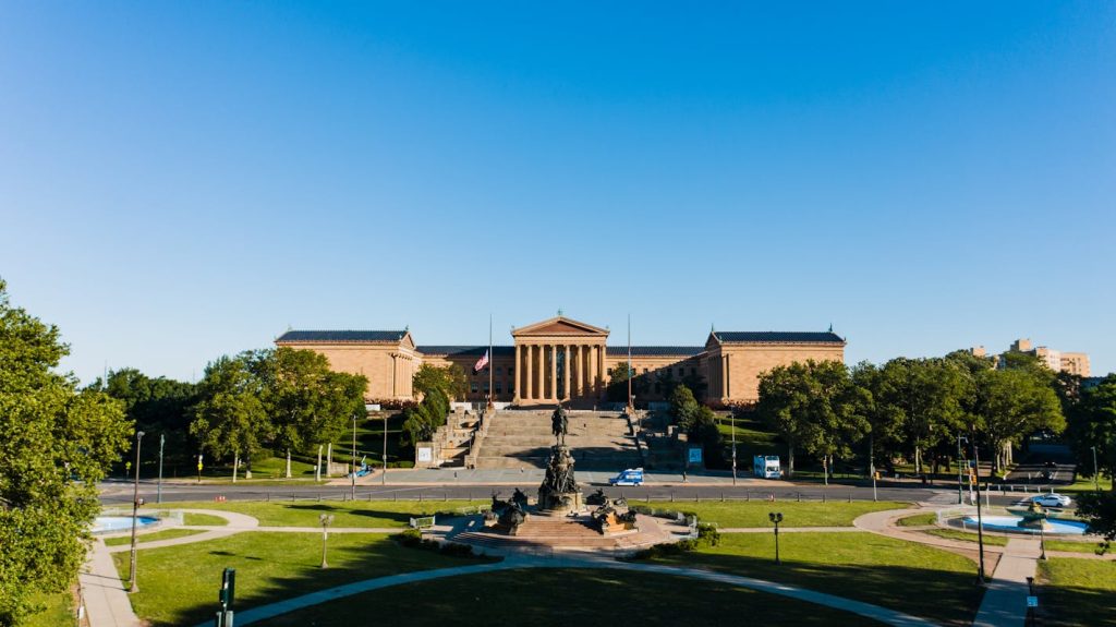 9 American Film Locations Where Travelers Can Relive Iconic Scenes – Her Life Adventures Old Museum of Art near sculptures and lawn in Philadelphia