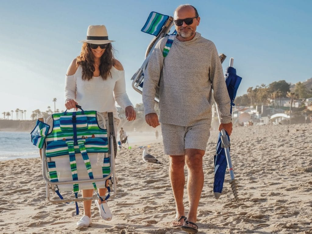 8 Travel Gear Items To Leave At Home For October Trips – Her Life Adventures A Couple Walking on a Beach
