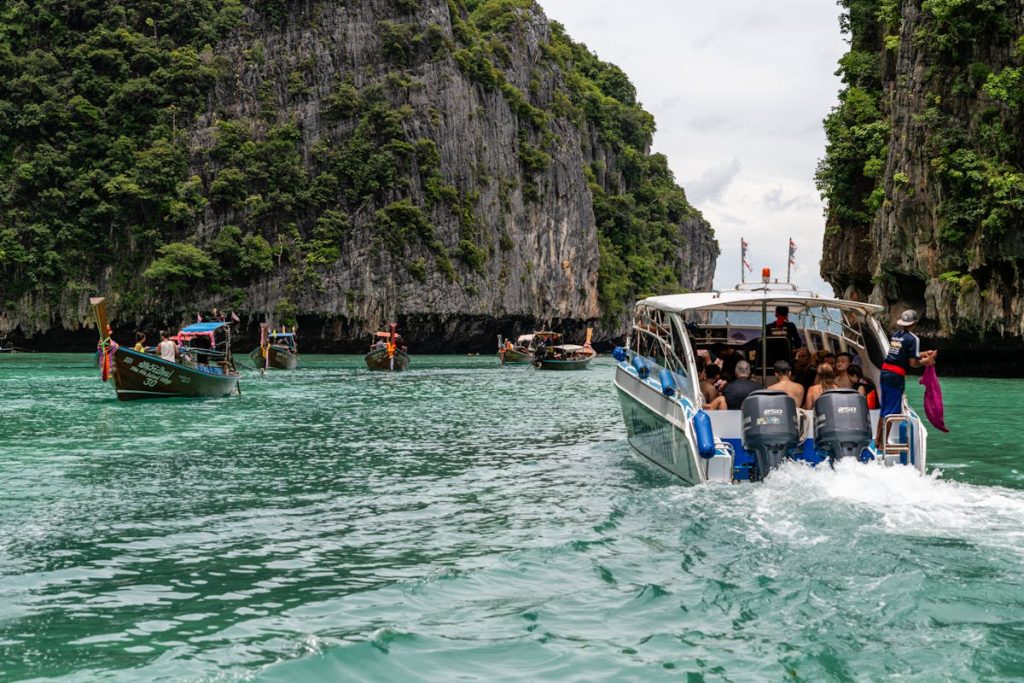 People Sailing between Tall Cliffs