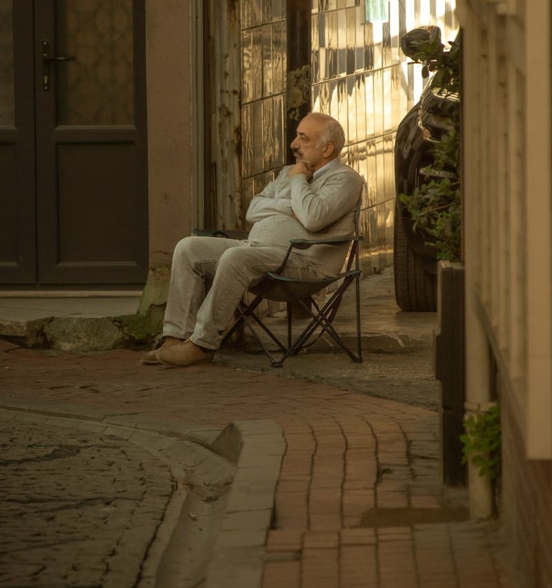 Photo of an Elderly Man Sitting on a Chair