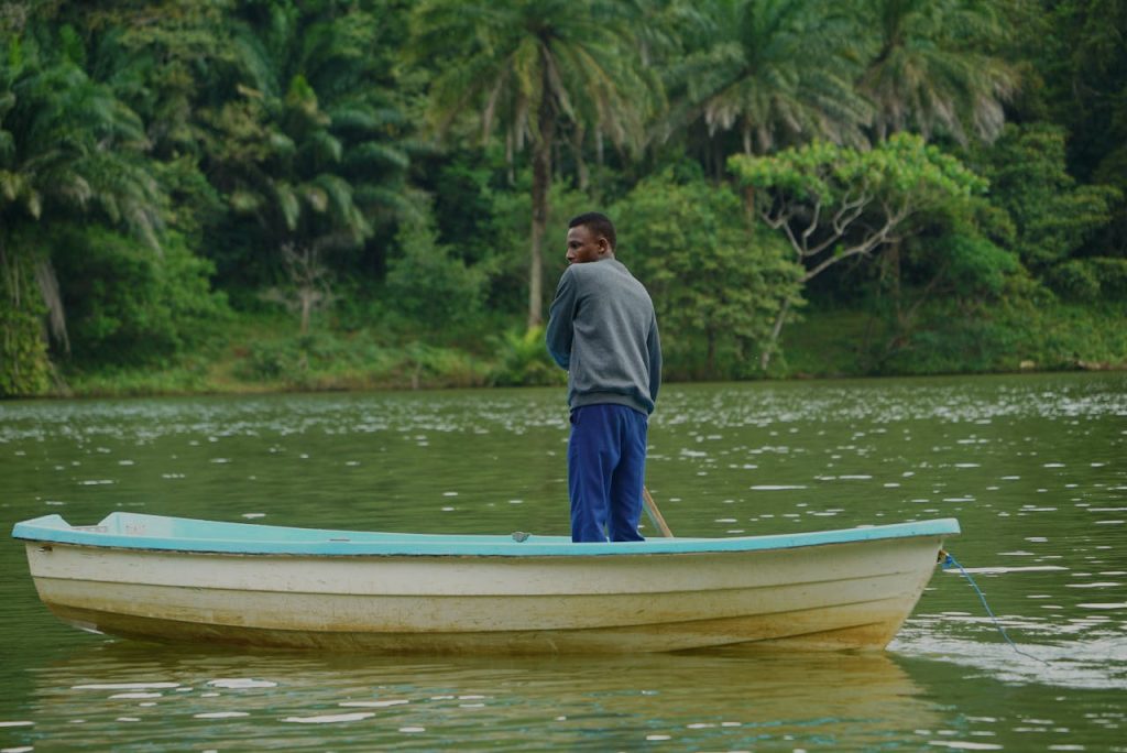 Man Rowing Boat on Lush Tanzanian Lake
