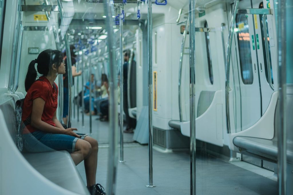 A clean modern metro or tram with travelers using smartphones
