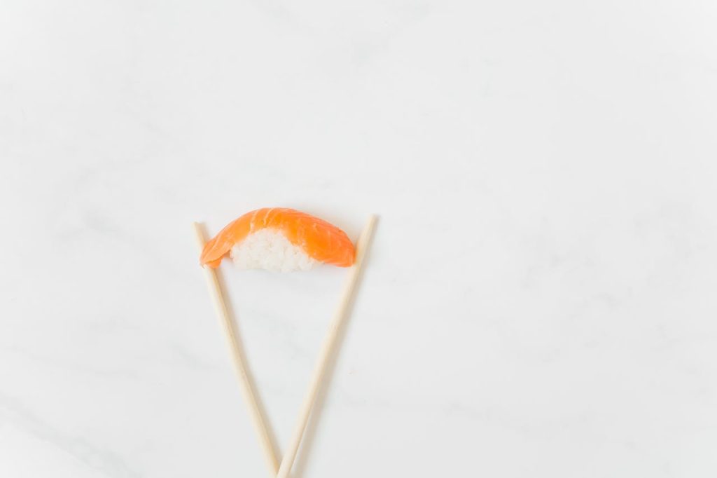 Nigiri Sushi Between Chopsticks