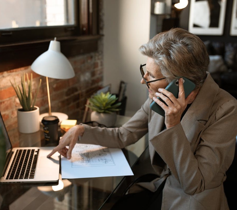 A Businesswoman Talking on the Phone while Using a Computer