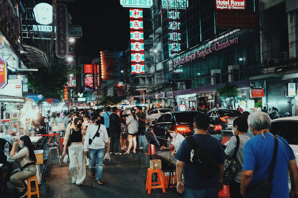 A busy food stall or night market with people enjoying local dishes.