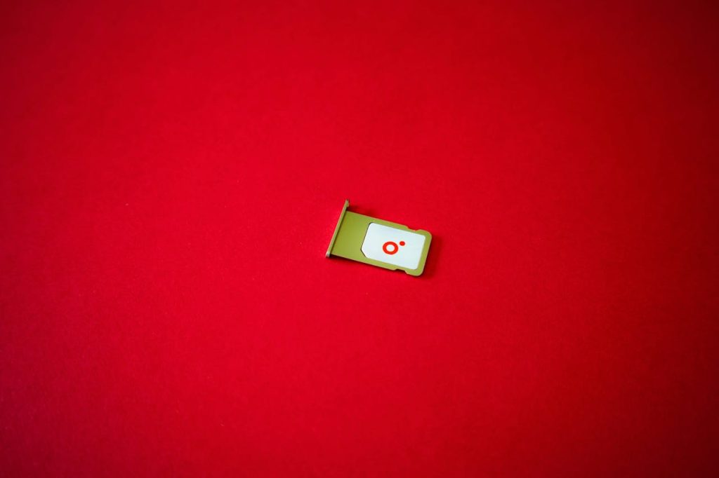 Minimalist SIM Card Tray on Red Background