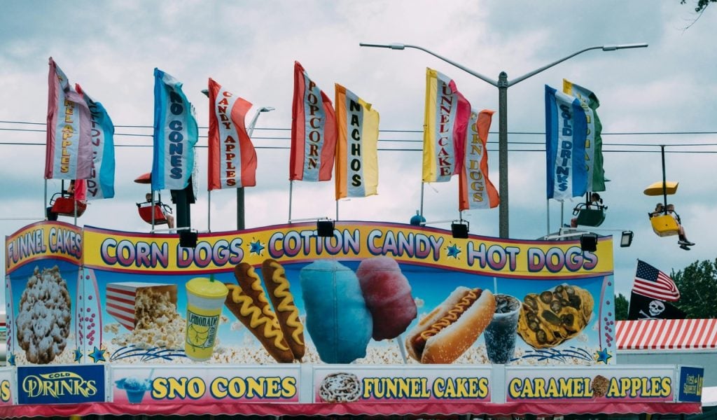 8 State Fairs with Big October Weekends – Her Life Adventures A carnival with a sign that says corn dog and hot dog