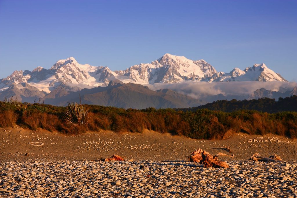 NZ Southern Alps mountain landscape in New Zealand seen from Gillespies Beach, West Coast - sunset light