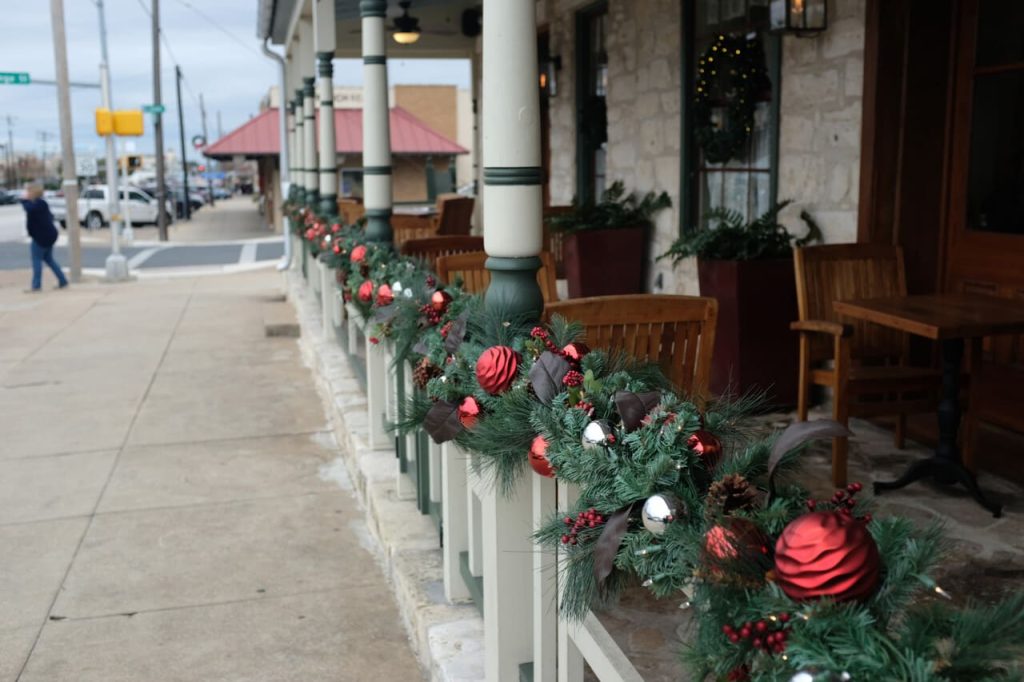 A beautiful shot of a restaurant terrace decorated with Christmas tree branches and ornamen