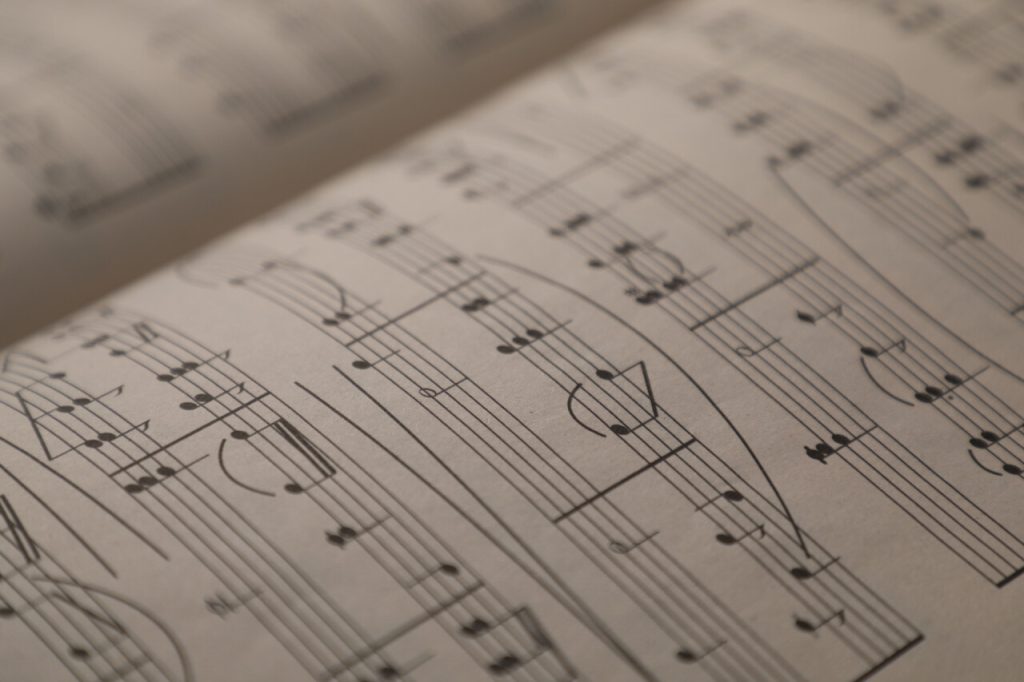 Sheets with musical notes as background, closeup