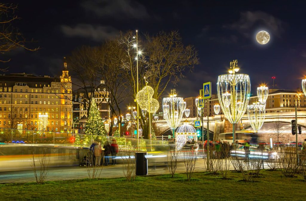 Wide shot of a park glowing with Christmas lights