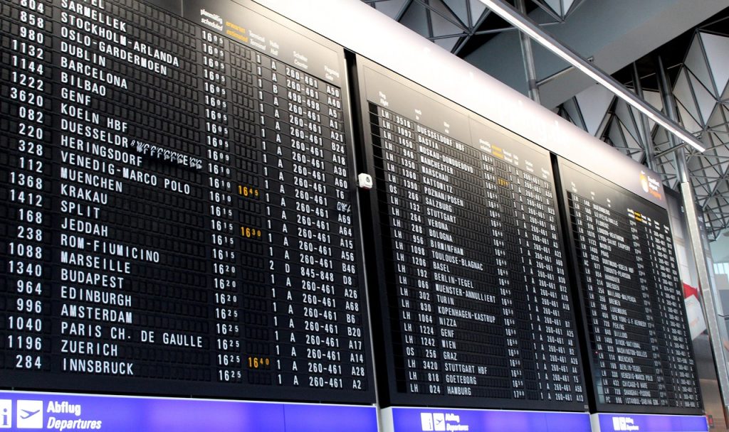 A wide shot of an airport departure board showing mixed fare levels