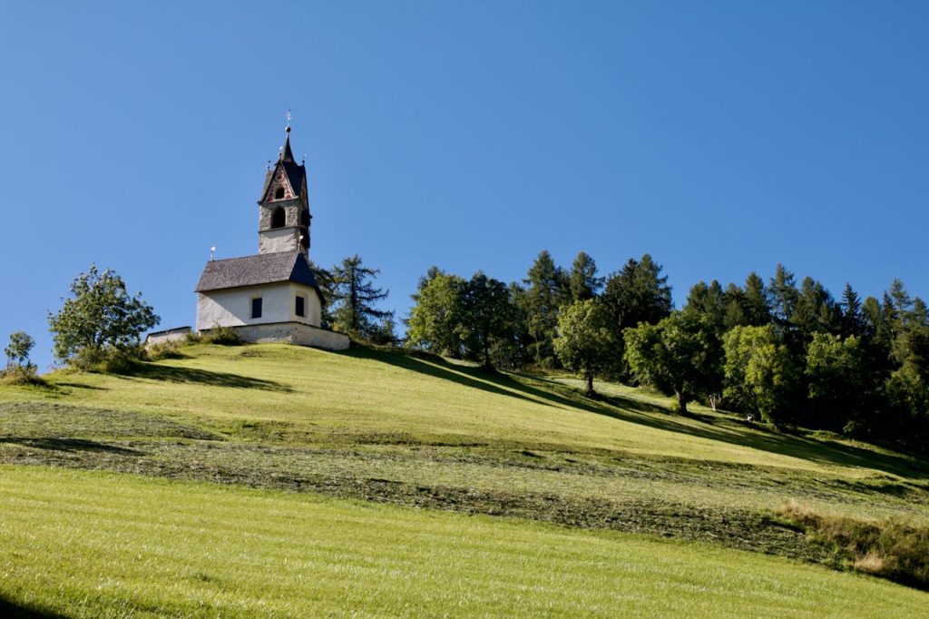 Wide landscape with a small chapel that feels rooted in place