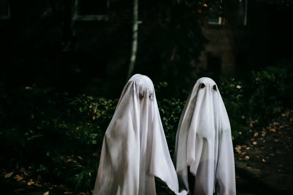 Unrecognizable children in ghost costumes in town

