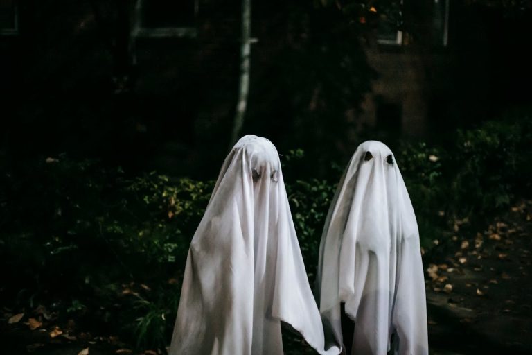 Unrecognizable children in ghost costumes in town