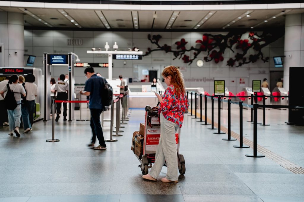 A traveler walking toward priority boarding signage.