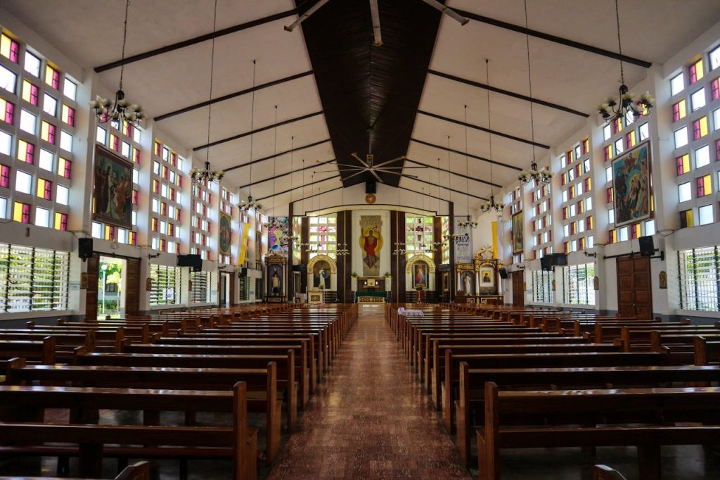 Empty wooden bench inside a compact chapel