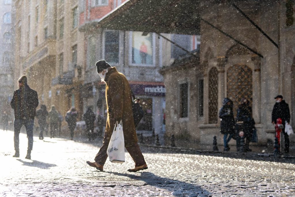 Man in Brown Jacket Walking on the Street