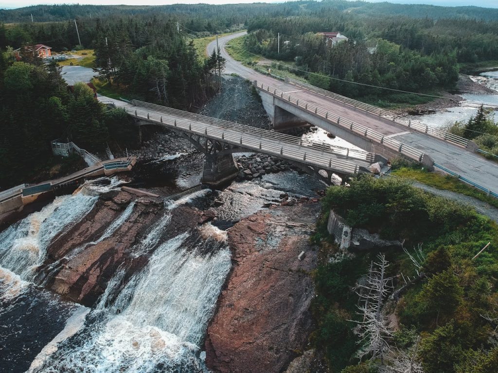 Old bridges above river and fast waterfalls in mounts
